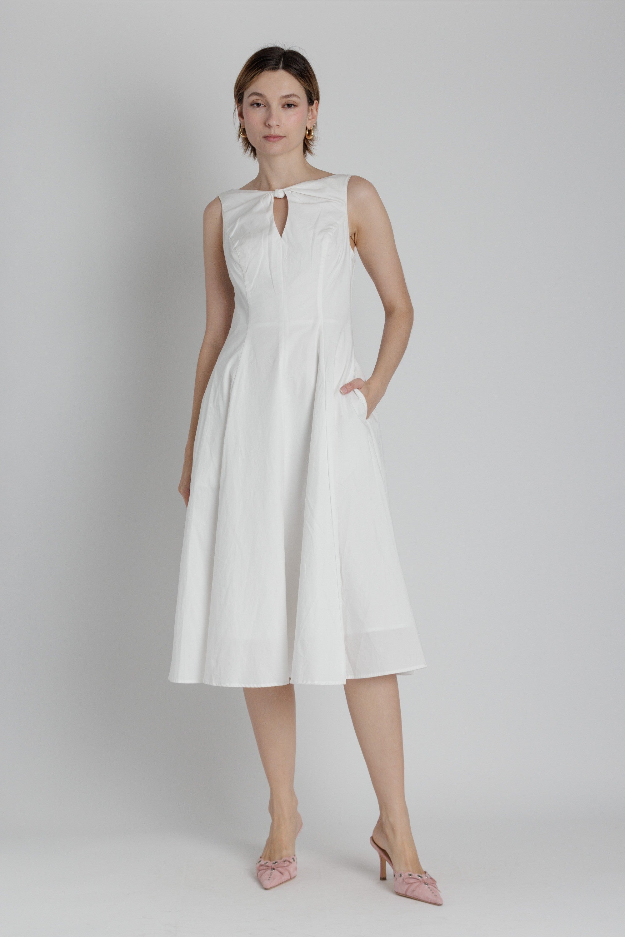 Woman wearing a white dress on a plain background