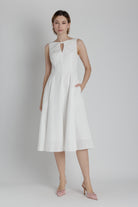 Woman wearing a white dress on a plain background