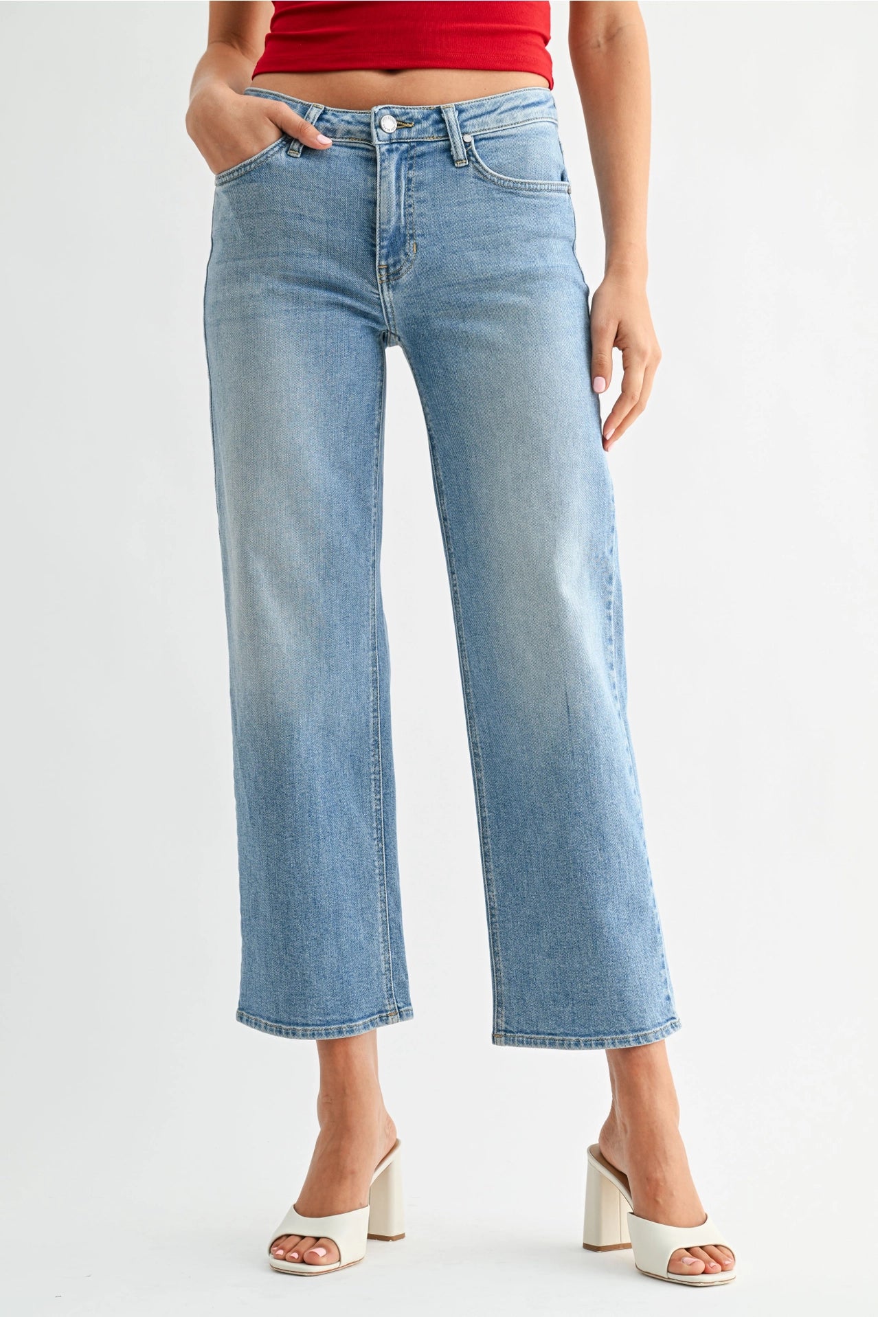 Person wearing light blue jeans on a white background
