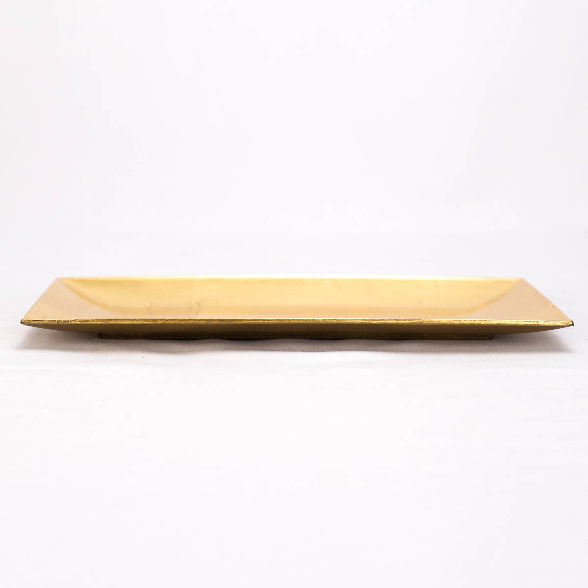 A rectangular gold ceramic serving platter with a glossy finish, photographed against a seamless white background.