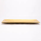 A rectangular gold ceramic serving platter with a glossy finish, photographed against a seamless white background.