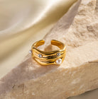 Gold ring with pearls and small stones on a stone surface