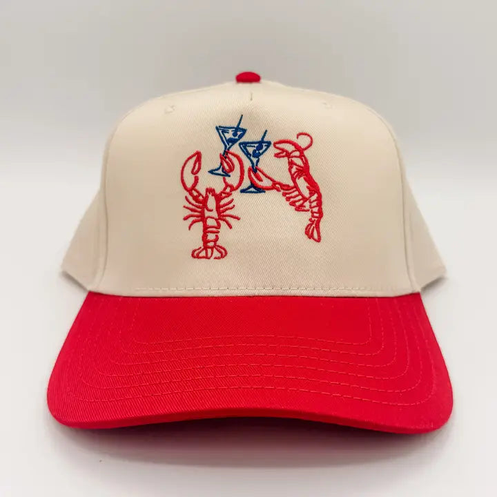 Beige and red cap with lobster and martini design on a white background