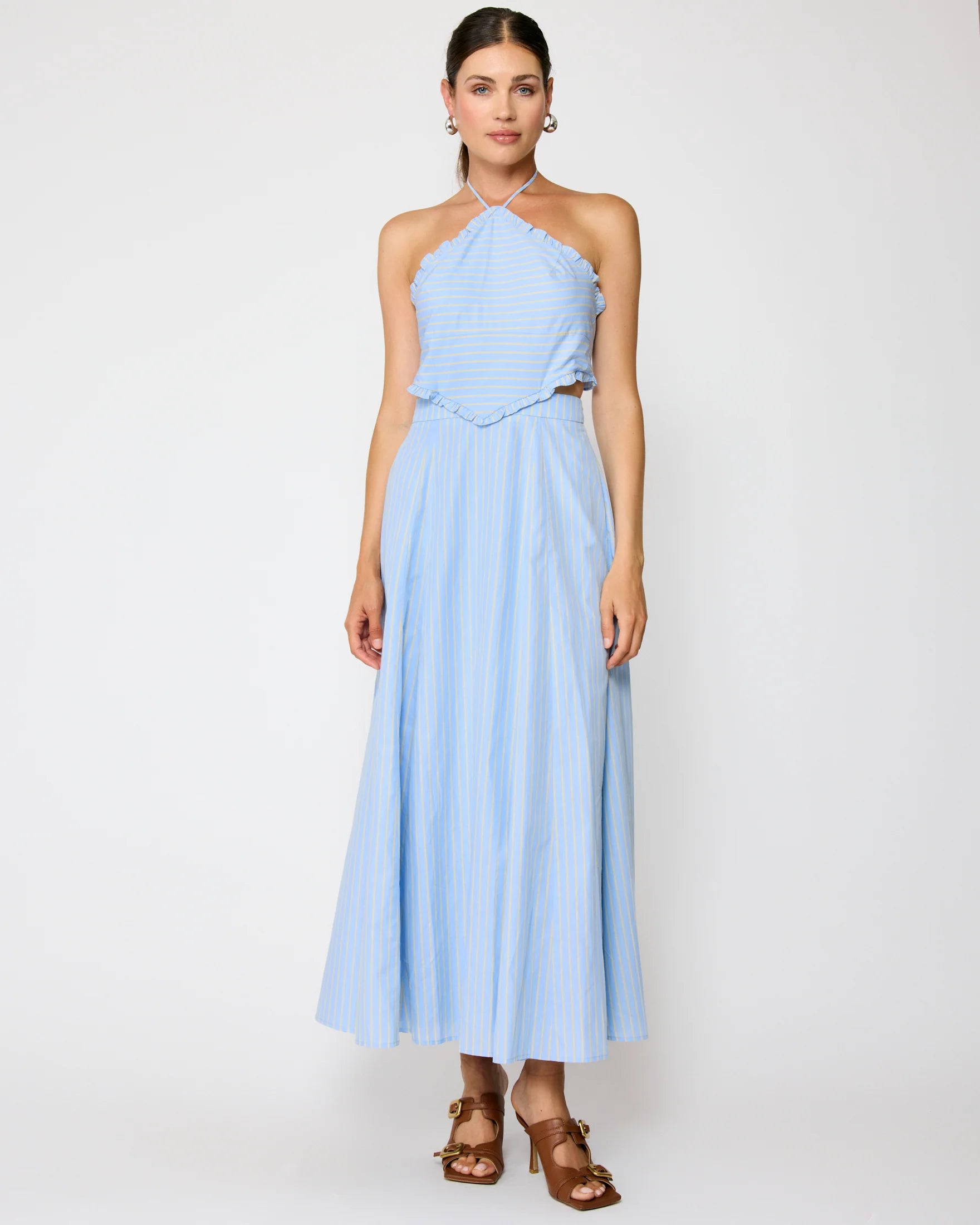 Woman wearing a light blue halter neck dress on a white background