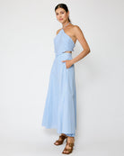 Woman wearing a light blue one-shoulder dress on a white background