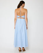 Woman wearing a light blue dress with thin straps on a white background