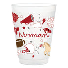 A clear plastic party cup with a white printed design featuring University of Oklahoma sports-themed doodles, including a megaphone, football, helmet, horse, and the name 'Norman' in red script.