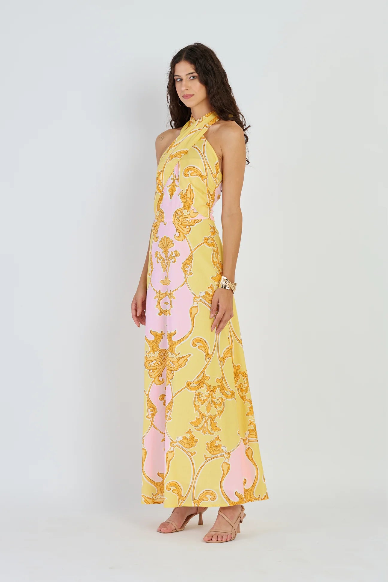Woman wearing a yellow floral dress on a white background