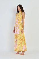 Woman wearing a yellow floral dress on a white background