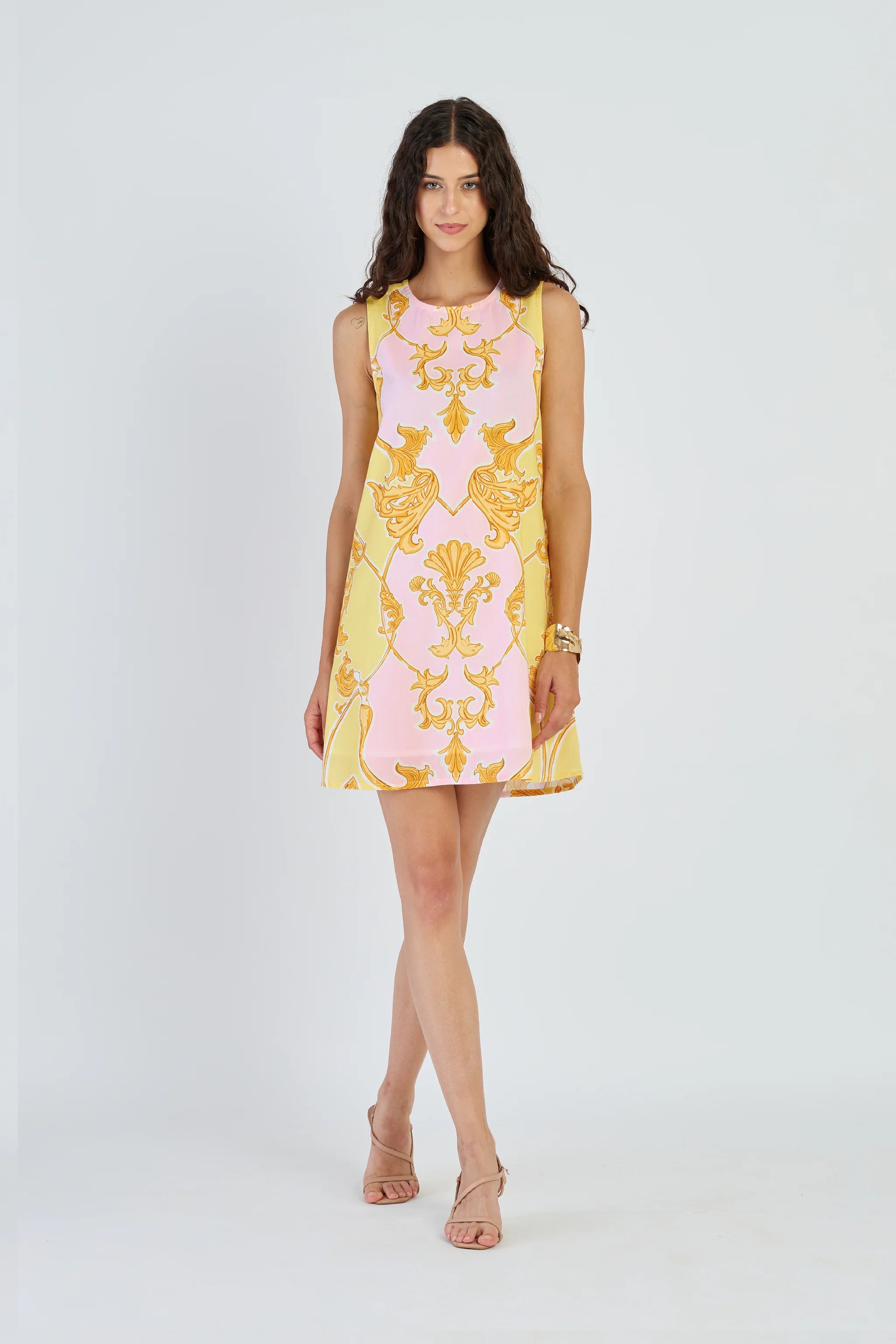 Woman wearing a yellow and pink patterned dress on a white background