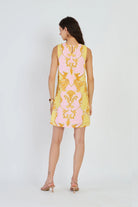 Woman wearing a pink and yellow patterned dress on a white background