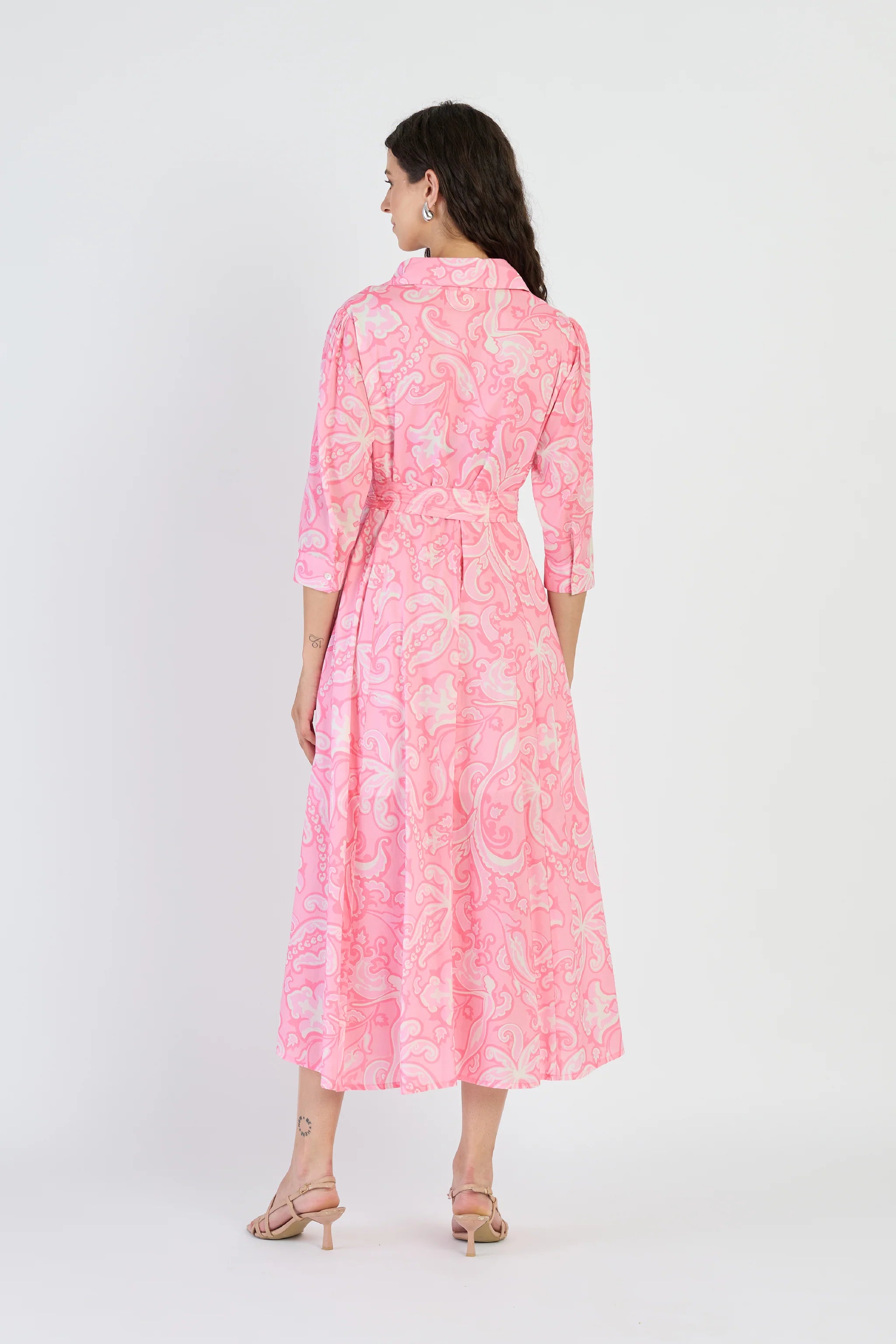 Woman wearing a pink floral dress on a white background