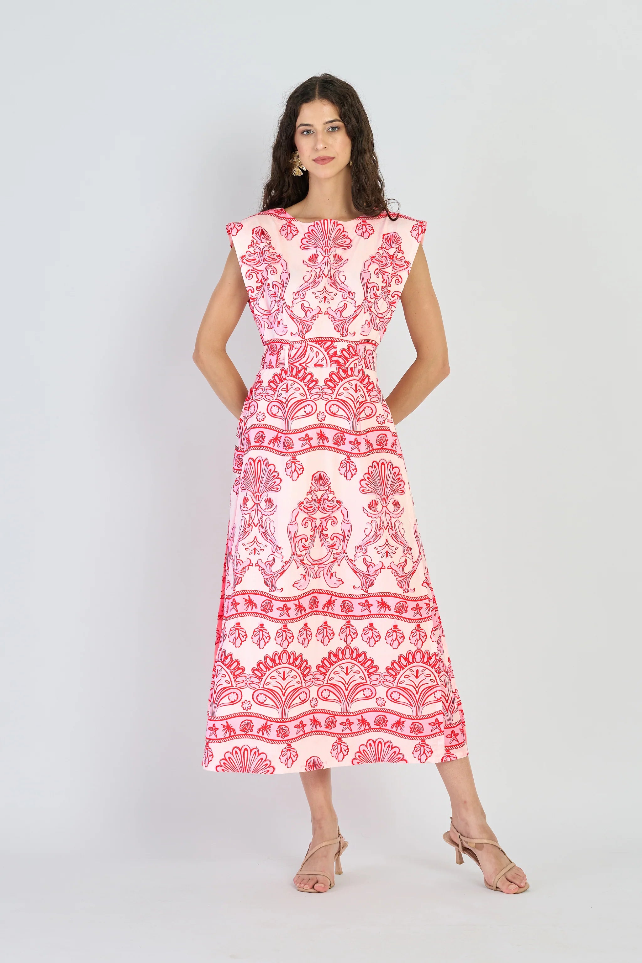 Woman wearing a red and white patterned dress on a white background
