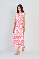Woman wearing a pink and white patterned dress on a white background
