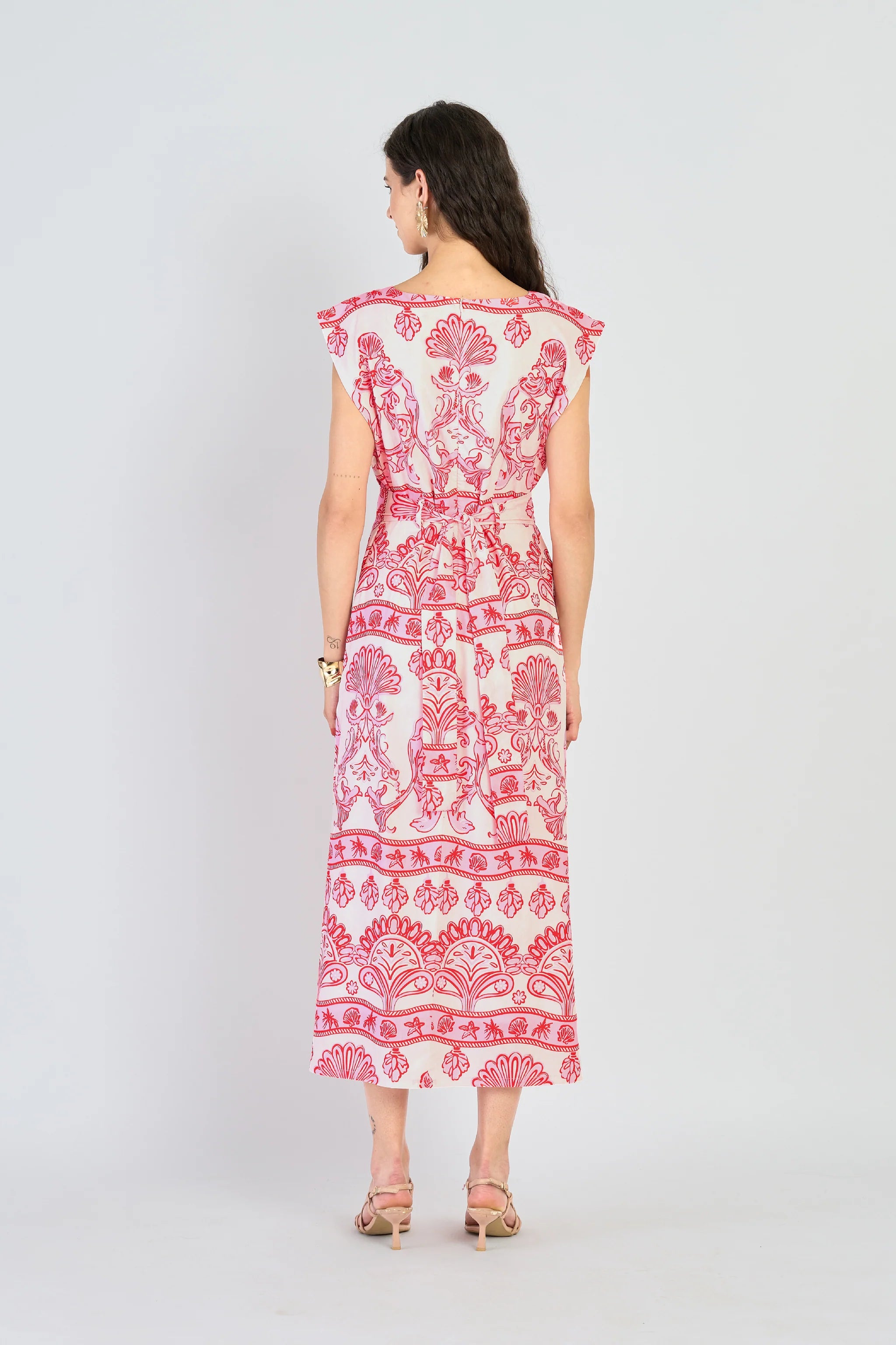 Woman wearing a red and white patterned dress on a white background