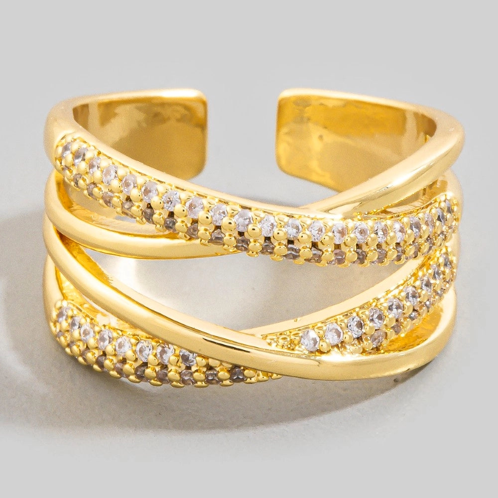 Gold ring with embedded stones on a light gray background