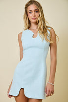 Woman wearing a light blue dress against a beige background