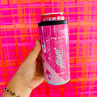 Pink energy drink can held by a hand against a colorful plaid background