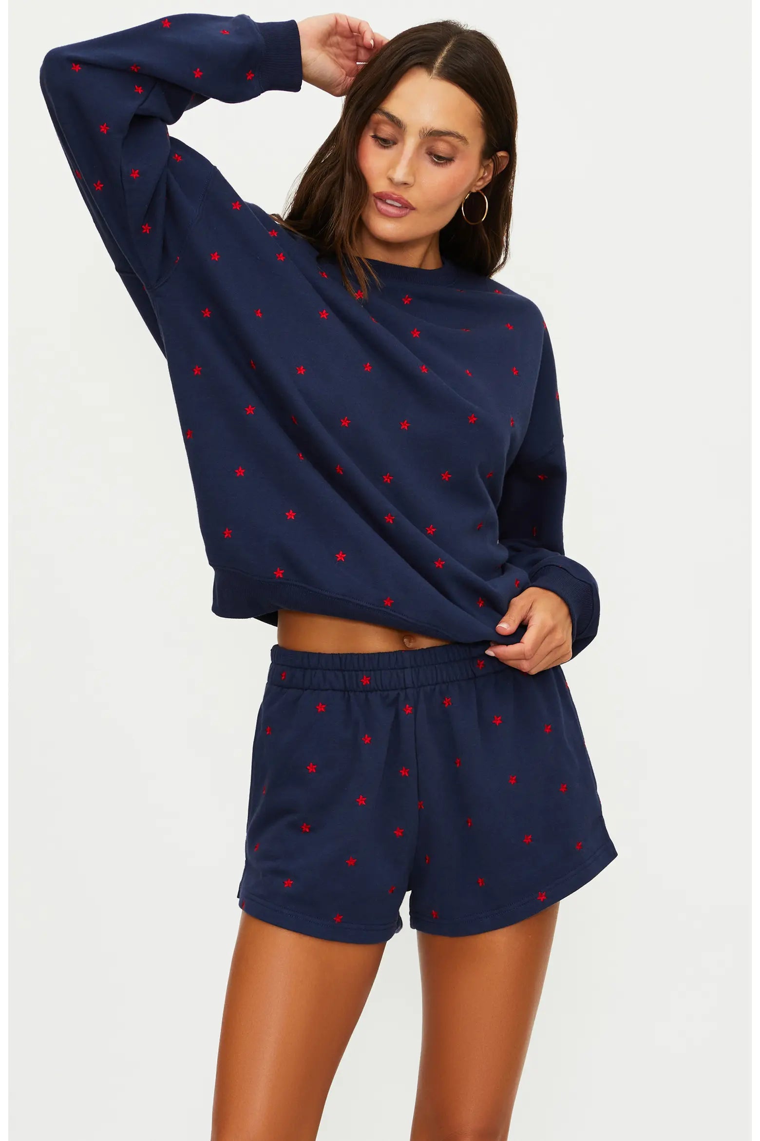 Woman wearing a navy blue outfit with red star patterns on a white background