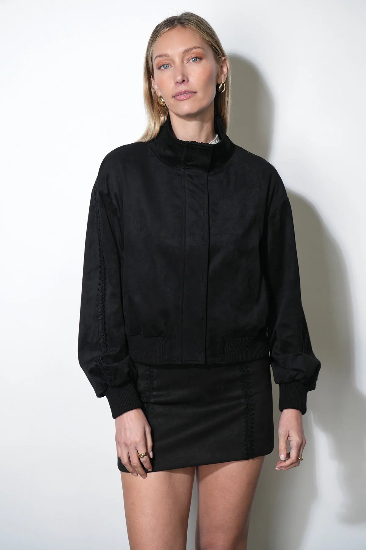 Woman wearing a black outfit against a white background
