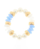 A beaded stretch bracelet featuring white faux pearls, light blue flat beads, and textured gold spacer rings, displayed on a clean white background.