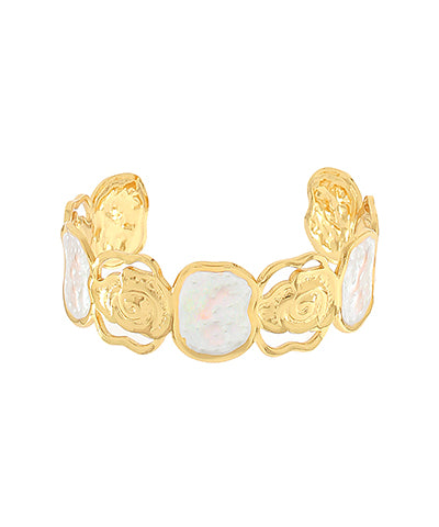 A gold-toned cuff bracelet featuring organic-shaped white iridescent opal inlays, photographed on a solid white background.
