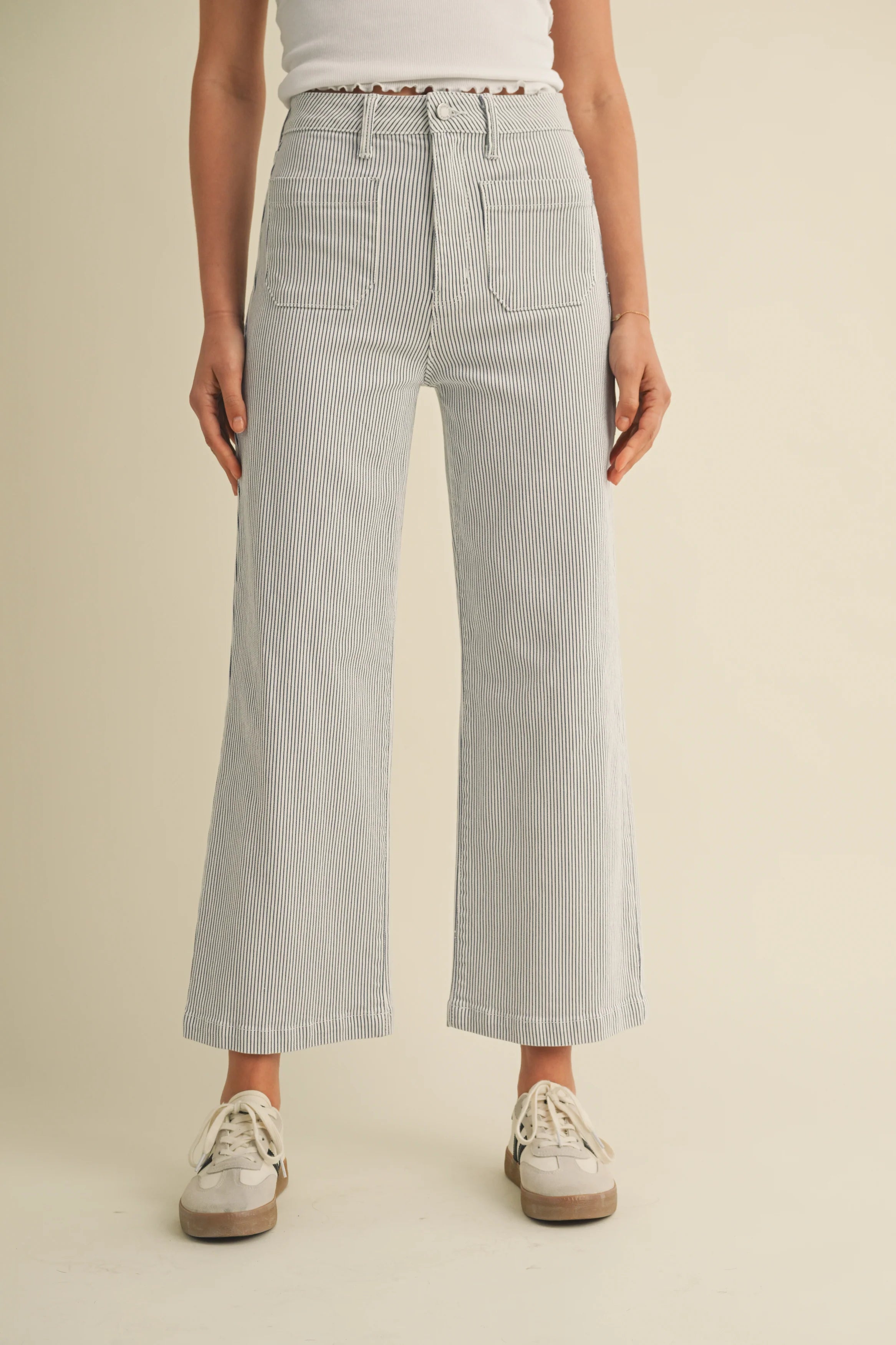 Person wearing striped pants on a beige background