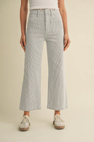 Person wearing striped pants on a beige background