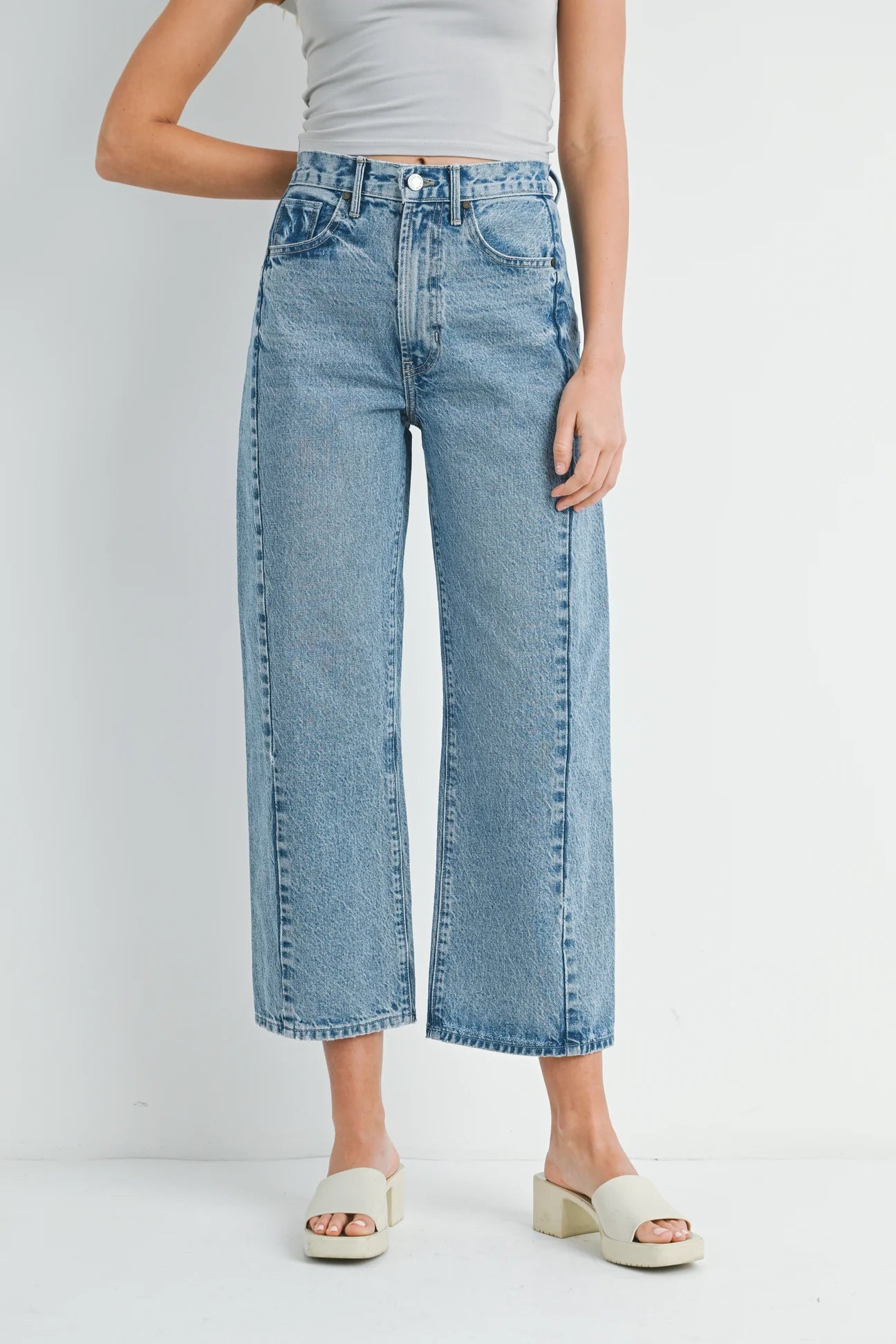 Person wearing light blue jeans on a white background