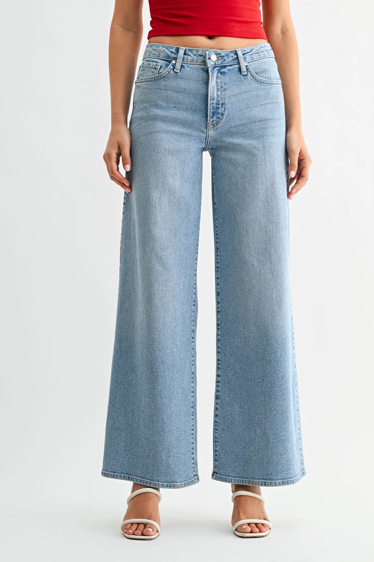 Person wearing light blue wide-leg jeans on a white background