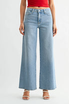 Person wearing light blue wide-leg jeans on a white background