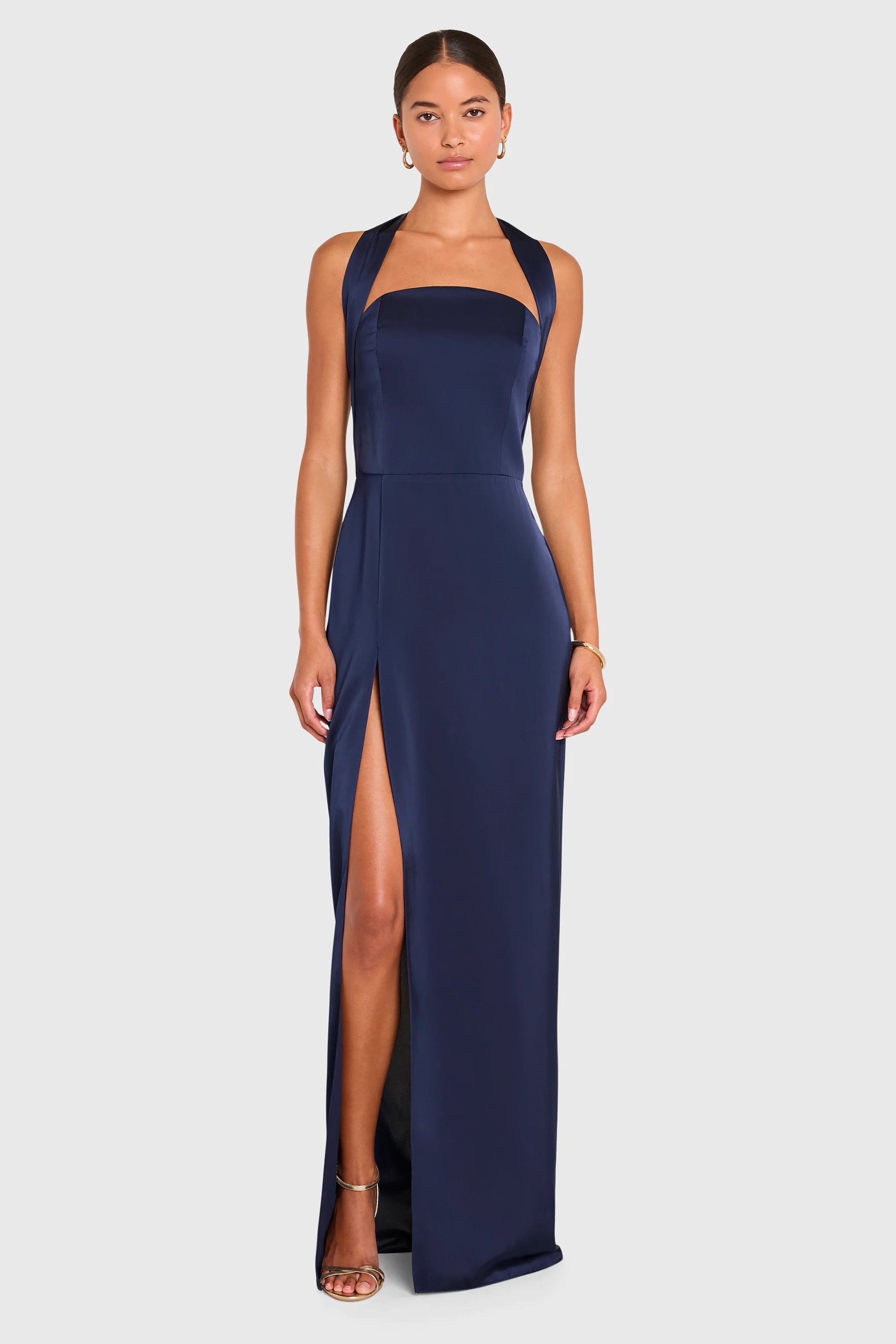 Navy blue halter neck gown with a high slit on a white background