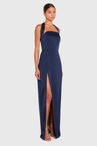 Navy blue halter neck gown with a high slit on a white background