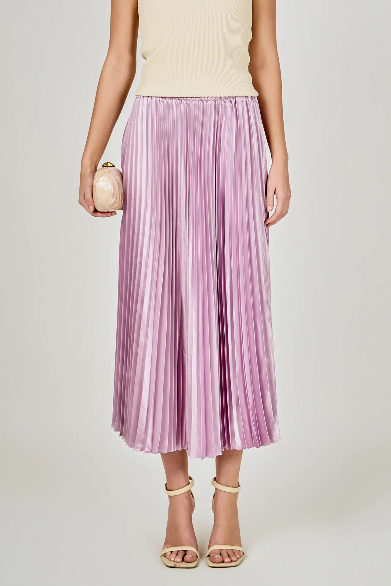 Person wearing a purple pleated skirt on a plain background