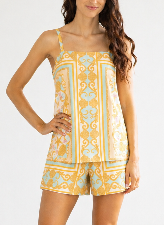 Woman wearing a yellow and blue patterned romper on a white background