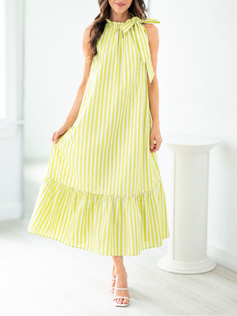 Woman wearing a yellow and white striped dress in a bright room.