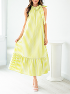 Woman wearing a yellow and white striped dress in a bright room.