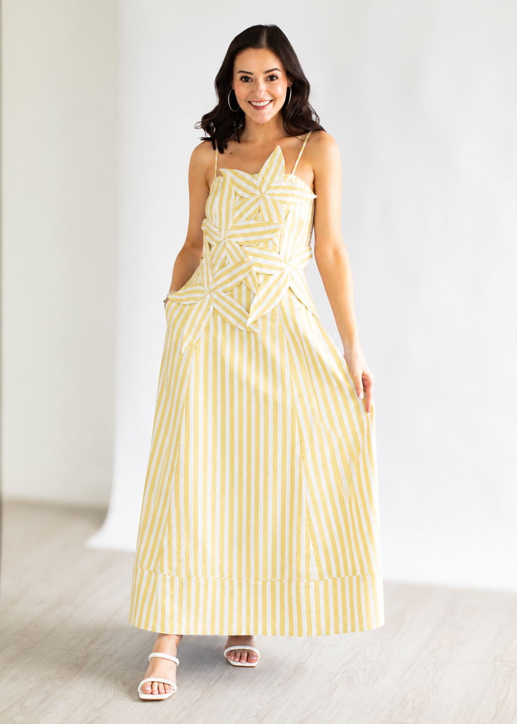 Woman wearing a yellow striped dress against a white background