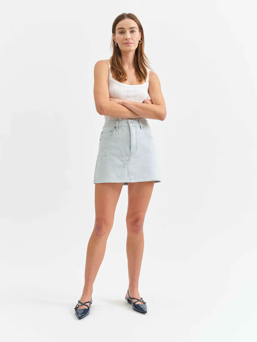 Woman wearing a light blue denim skirt on a white background