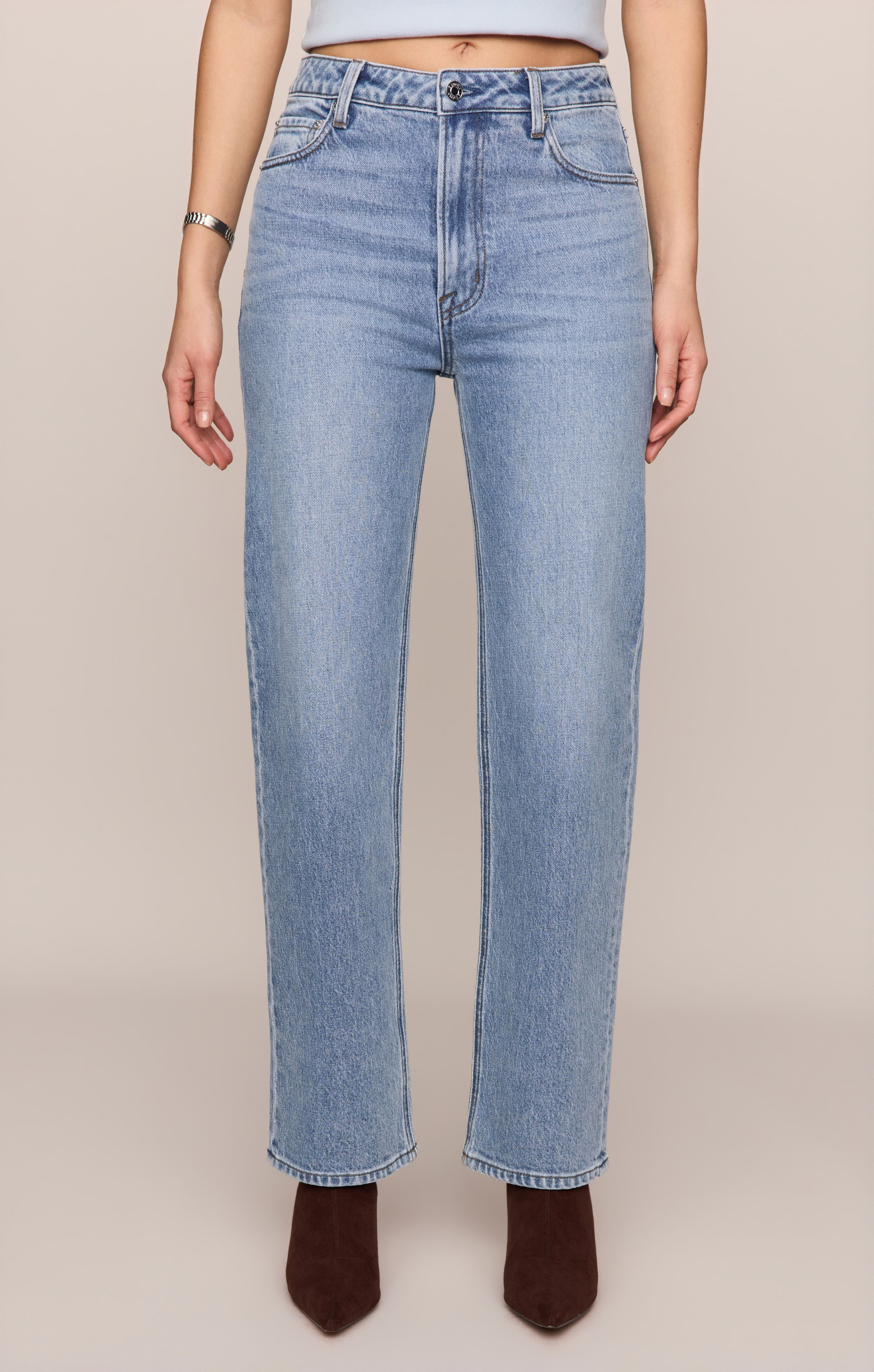 Light blue jeans worn by a person on a beige background