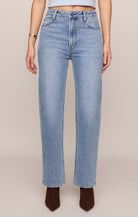 Light blue jeans worn by a person on a beige background