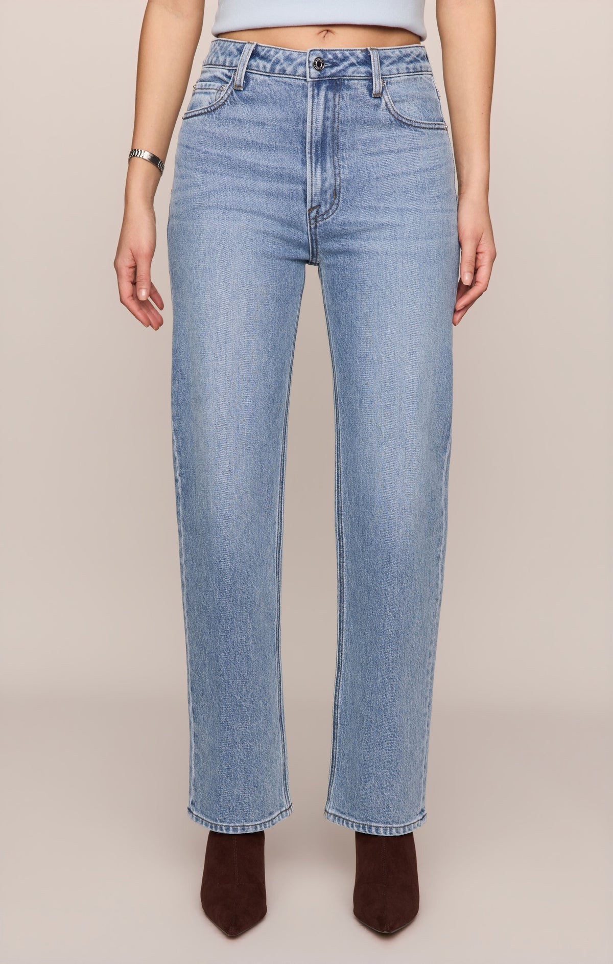 Light blue jeans worn by a person on a beige background