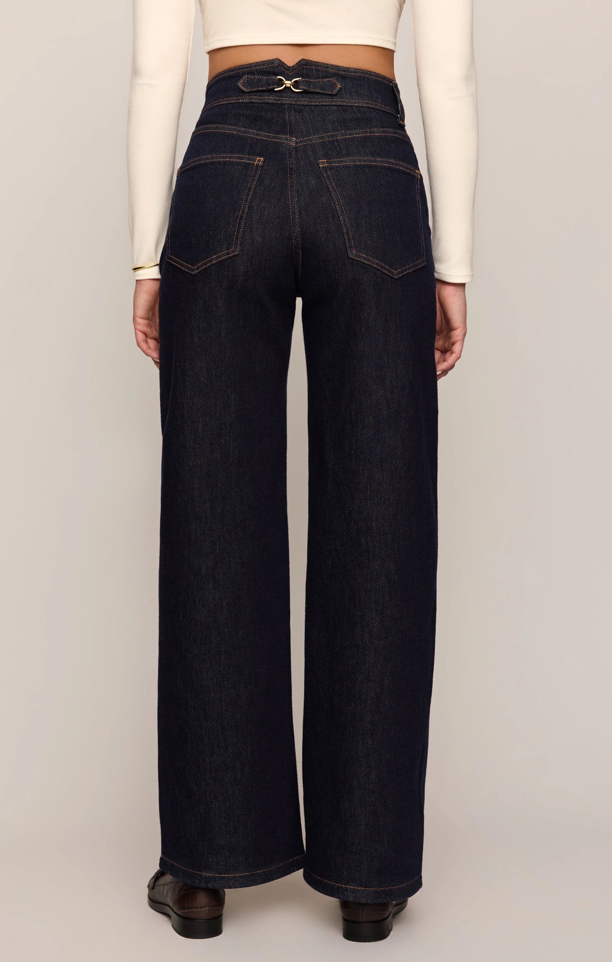 Person wearing dark blue jeans with a white background