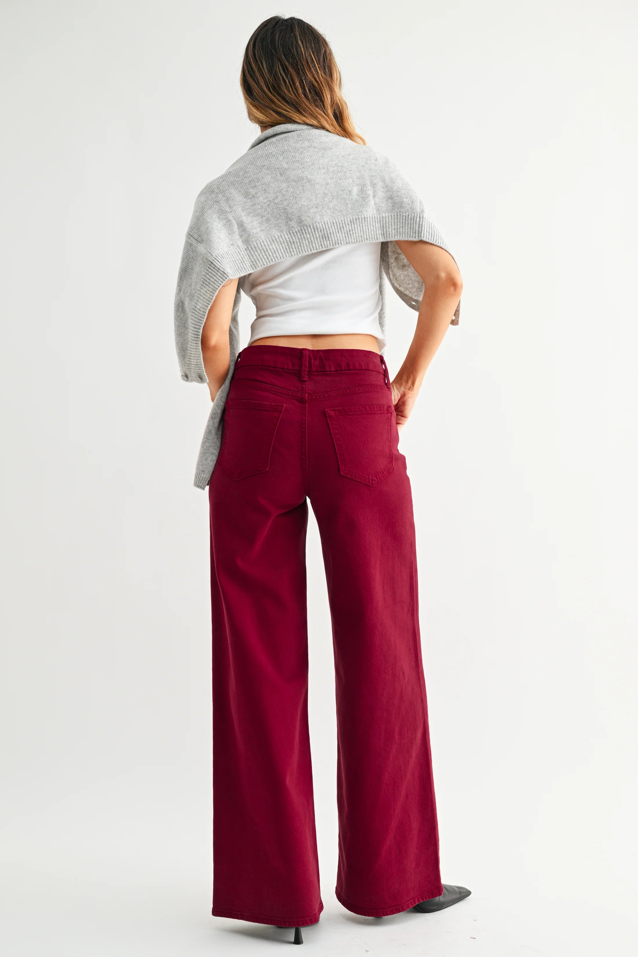 Person wearing a white top and red pants on a white background