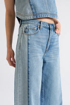 Light blue jeans worn by a person on a white background