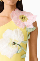 Yellow dress with floral appliqués on a white background