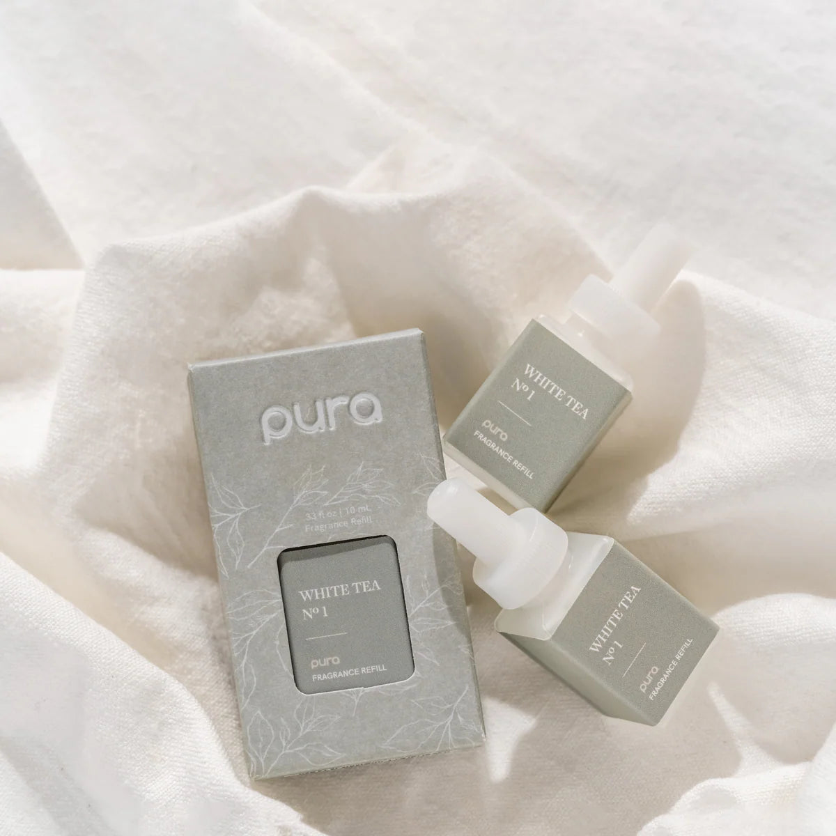 Pura White Tea products on a soft white fabric background