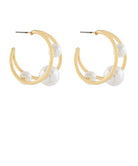 Gold hoop earrings with white pearls on a white background