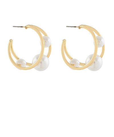 Gold hoop earrings with white pearls on a white background
