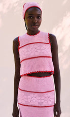 Model wearing a pink and red crochet outfit against a white background